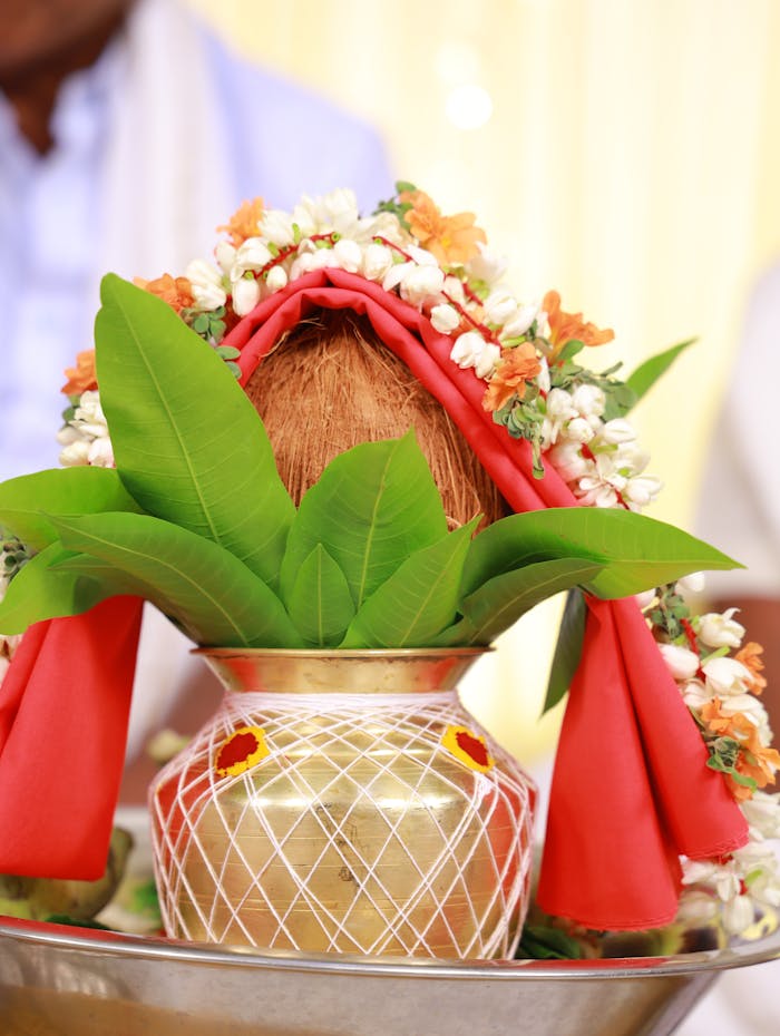 Vibrant shot of a traditional Kalash adorned with coconut, leaves, and flowers.