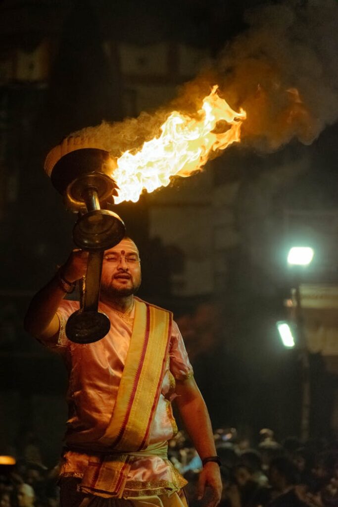 A Hindu priest performs Ganga Aarti ritual at night in Varanasi, India.